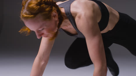 Studio-Shot-Of-Mature-Woman-Wearing-Gym-Fitness-Clothing-Doing-Mountain-Climber-Exercise-4